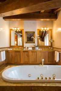 布勒伊-切尔维尼亚希尔米塔吉罗莱夏朵精品酒店的浴室内的大型白色浴缸配有两面镜子