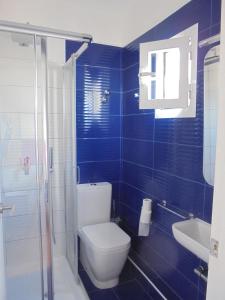 伊维萨镇Huéspedes Sa Font的蓝色瓷砖浴室设有卫生间和水槽