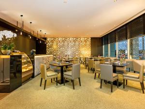迪拜Flora Creek Deluxe Hotel Apartments, Deira的一间带桌椅和灯光的餐厅