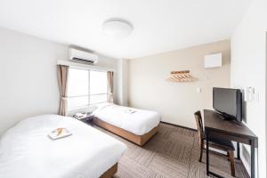 东京最佳酒店的酒店客房设有两张床和一张书桌及电视