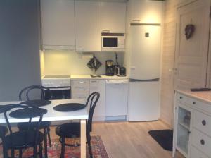 列维Lumi City Apartment的厨房配有桌椅和冰箱。