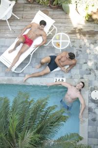 劳德代尔堡Pineapple Point Guesthouse & Resort - Gay Men's Resort的两个人躺在游泳池里