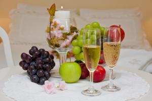坎波斯杜若尔当Pousada Portal das Cerejeiras by Platanus的桌上的两杯香槟和水果