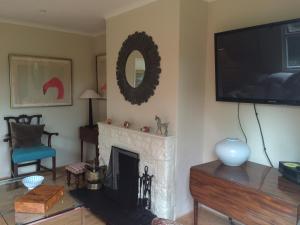 MaidfordYew Tree Cottage的客厅设有壁炉和平面电视。