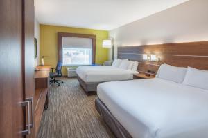 特克萨卡纳-德克萨斯Holiday Inn Express & Suites Texarkana, an IHG Hotel的酒店客房配有两张床和一张书桌