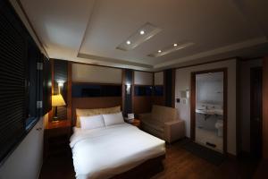首尔驿三贵族酒店的卧室配有白色的床和椅子