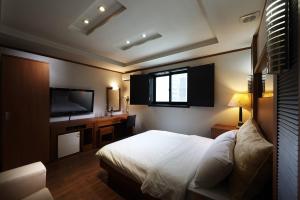 首尔驿三贵族酒店的一间卧室配有一张床和一台平面电视