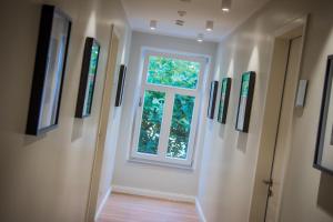 林根林根博格酒店的走廊上设有窗户,墙上挂有绘画作品