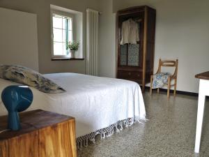 MillesimoI Calleri Garden and Rooms的一间卧室配有一张床、梳妆台和椅子