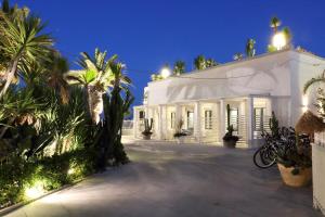 特拉尼拉贝拉特拉尼住宿加早餐旅馆的一座白色的建筑,有棕榈树和灯