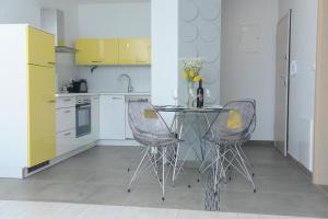 里耶卡Apartment Livingstone的厨房配有玻璃桌和两把椅子