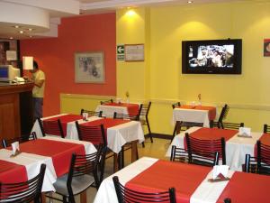 布宜诺斯艾利斯Hotel Esperia的一间设有桌子的用餐室和墙上的电视