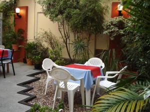 布宜诺斯艾利斯Hotel Esperia的花园内的桌椅,配有红色的桌子和椅子