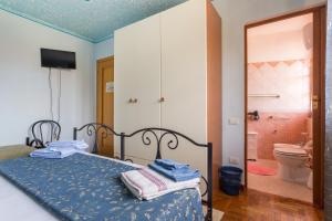 奥里斯塔诺B&B Il Mirto的一间卧室配有一张床,浴室设有卫生间