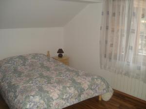 代温Kisiovi Apartment的一间卧室配有一张带花卉床罩的床