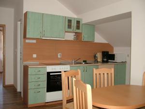 代温Kisiovi Apartment的厨房配有绿色橱柜和木桌