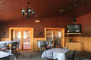 WetmoreQuality Inn & Suites Munising的餐厅设有桌椅和平面电视。