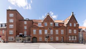 奥尔堡赫尔南凤凰酒店的街道上一座大型红砖建筑