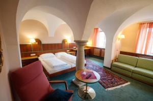 多瑙河畔阿沙赫盖斯特豪弗索尼酒店的酒店客房配有床、沙发和桌子。