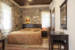库古库俞和耐普涵酒店的一间卧室设有一张床和石墙