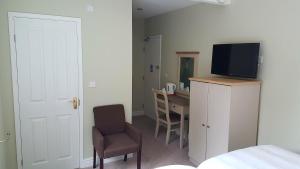 海维康雷克特酒店 的一间卧室配有一张床、一台电视和一张书桌