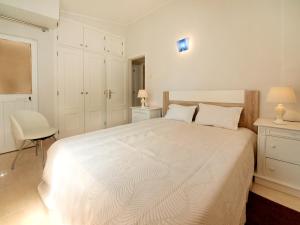 拉戈斯Apartment in Lagos的白色卧室配有白色的床和椅子