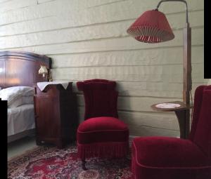 格里姆斯塔Gjestehuset IBSEN的一间卧室配有椅子、一盏灯和一张床