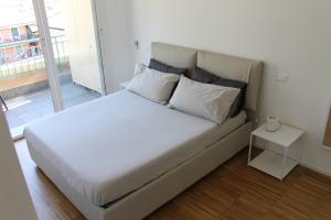 基亚瓦里BiancAdele sul mare的一张带白色床单和枕头的床