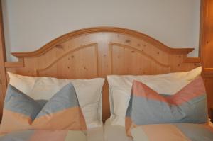 英格堡Hotel Engelberg "das Trail Hotel"的一张带木制床头板和两个枕头的床