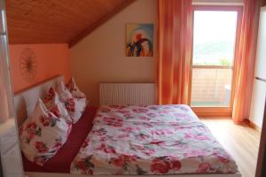 圣乌尔班Haus zur Sonne的一间卧室配有一张带花卉床罩的床和窗户。