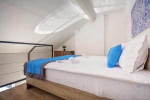萨拉热窝享受公寓的一间卧室配有一张带蓝色和白色枕头的床