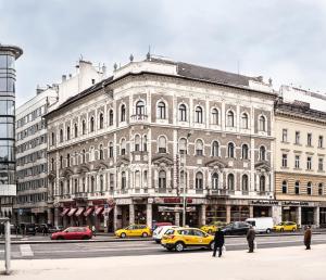 布达佩斯苏斯44号酒店的一座大型建筑,前面有汽车停放