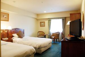 仙台仙台国分町大露台酒店 的酒店客房设有两张床和一台平面电视。