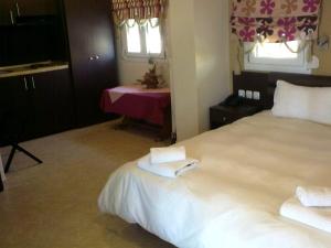 沃洛斯色赛旅馆的一间卧室配有一张床,上面有两条毛巾