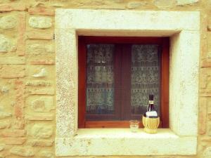 波吉邦西Casa ai Carfini的窗户边的一瓶葡萄酒