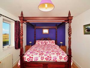斯塔芬Beinn Edra apartment的一间卧室配有一张带紫色墙壁的天蓬床