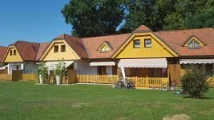 摩拉瓦托普利采Soncnica Apartment的一座大型黄色房子,自行车停在院子里