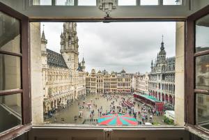 布鲁塞尔Résidence-Hotel Le Quinze Grand Place Brussels的从带雨伞的城市广场窗口欣赏美景