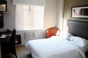 约翰内斯堡伊洛沃酒店的卧室配有白色的床和窗户。