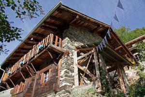 Le TrétienLieu Secret dans les Alpes Suisses的房屋的顶部设有木制阳台