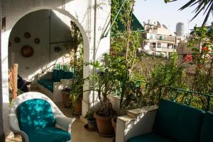开罗扎马雷克荷露斯酒店的大楼内的阳台配有蓝色椅子和植物