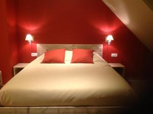 布兰肯贝赫Kokkelikoo的红色卧室配有带2个红色枕头的床