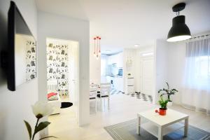 埃格尔Enjoy Apartman Eger的白色的客厅配有桌子和饭厅