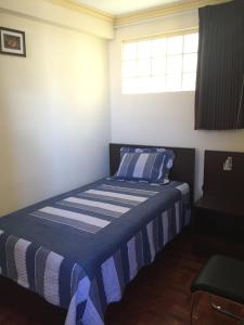 拉巴斯阿兰达维斯塔住宿加早餐旅馆的一间卧室配有一张带蓝白条纹毯子的床