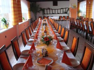 Klobouky u BrnaMotel Podkova的长长的用餐室配有长桌子和椅子