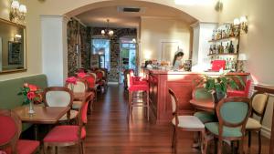 埃尔莫波利斯Hotel Aktaion Syros的一间设有红色椅子的餐厅和一间酒吧