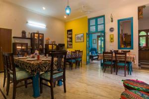 阿格拉珊瑚阁民宿的用餐室设有桌椅和黄色的墙壁