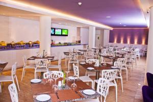 埃尔阿瓜Agua Dorada Beach Hotel By Lidotel的用餐室配有桌子和白色椅子