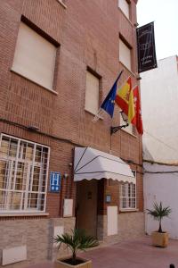 阿尔卡拉德荷那利斯Hotel Cuatro Caños的一面有旗帜的建筑