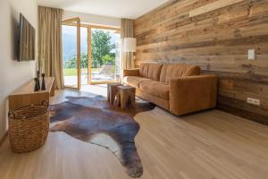 斯拉德明Sun Lodge Schladming by Schladming-Appartements的带沙发和木墙的客厅